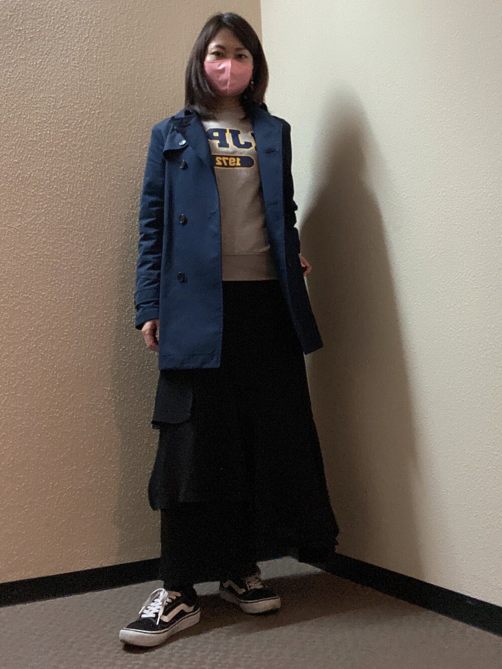 ブラック系のスカート、グレー系のスウェット、ブラック系のスニーカーを着用したレディースの春コーディネートの2枚目の写真