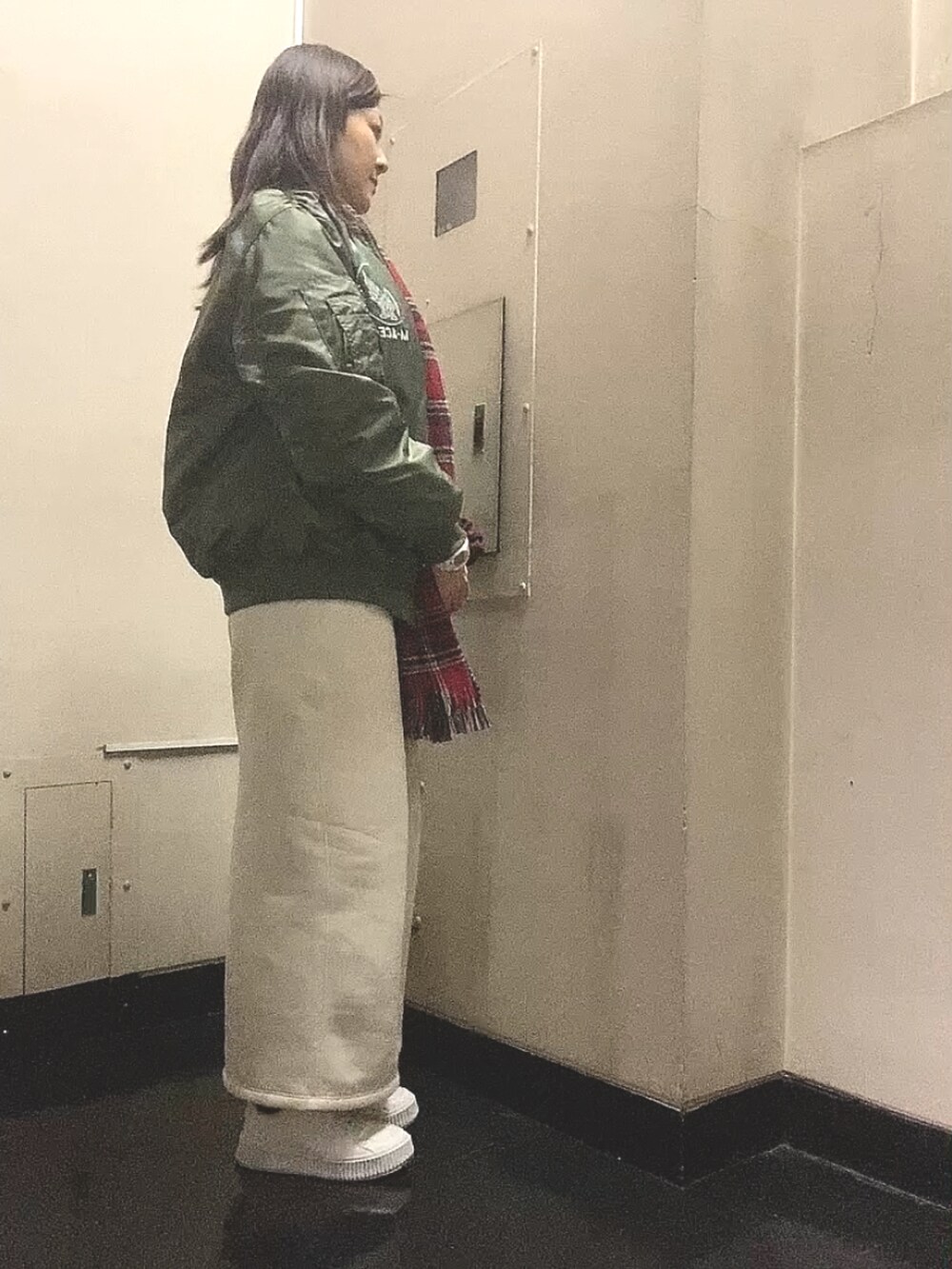 グリーン系のMA-1、ホワイト系のスカート、ホワイト系のスニーカーを着用したレディースの春コーディネートの2枚目の写真