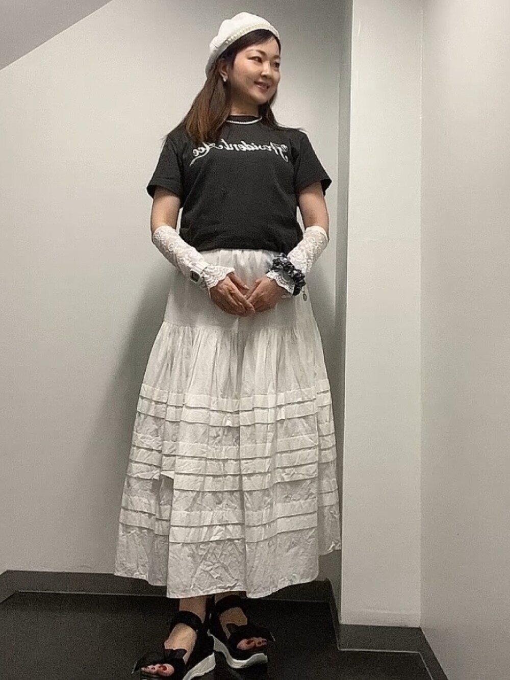 グレー系のTシャツ/カットソー、ホワイト系のスカート、ブラック系のベストを着用したレディースの夏コーディネートの2枚目の写真