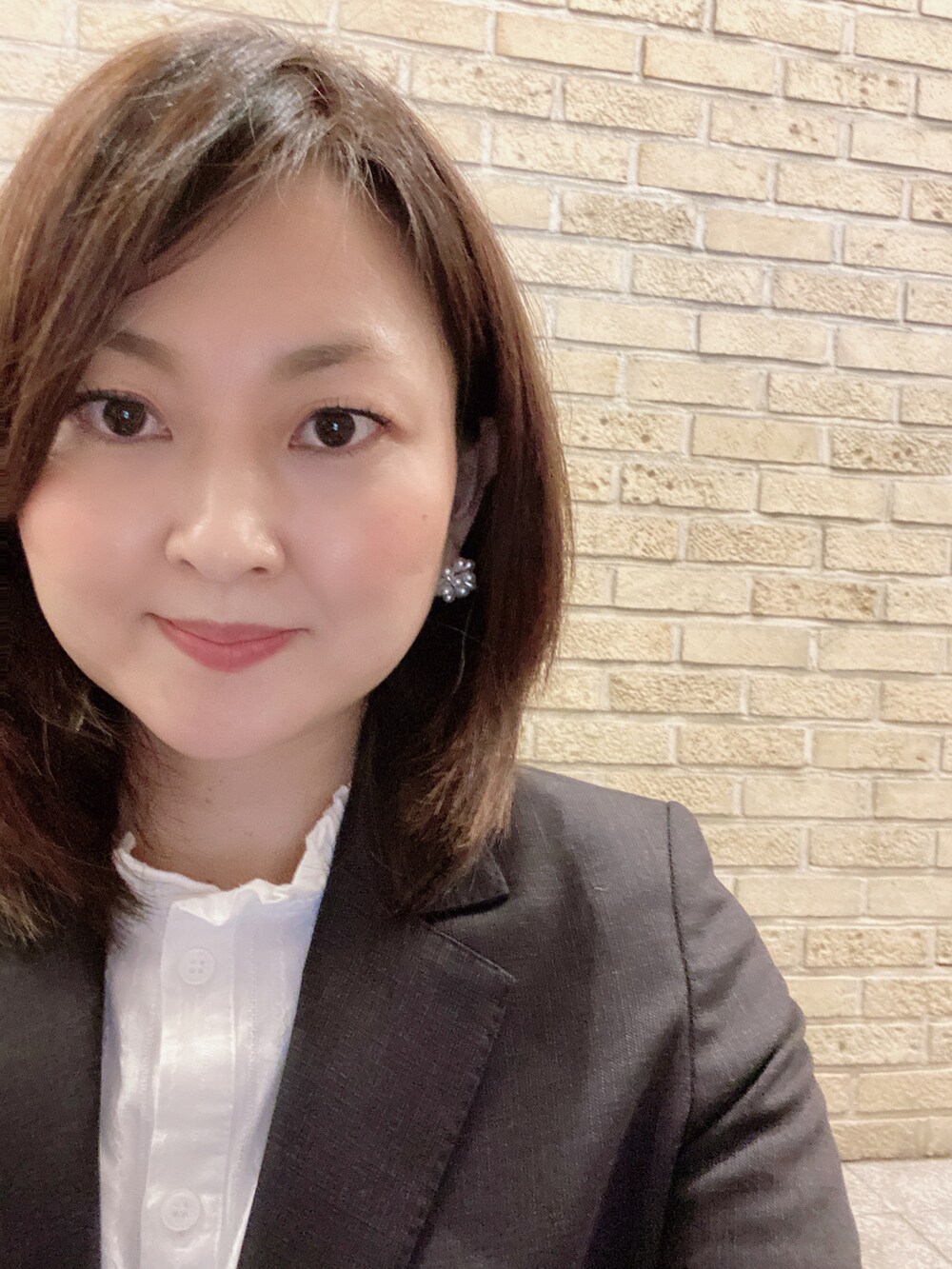 ホワイト系のシャツ/ブラウス、ブラウン系のスーツセット、ベージュ系のパンプスを着用したレディースの冬コーディネートの3枚目の写真