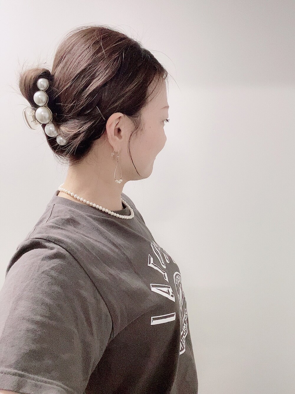 イエロー系のスラックス、ホワイト系のサンダル、グレー系のTシャツ/カットソーを着用したレディースの夏コーディネートの4枚目の写真