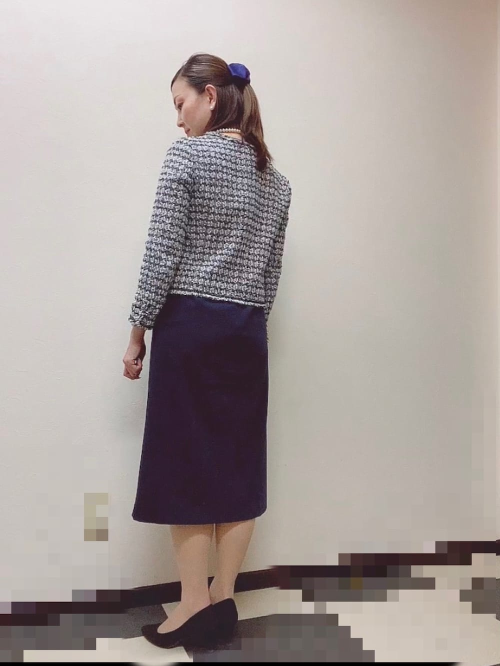 ブルー系のスーツセット、ブラック系のパンプス、ホワイト系のネックレスを着用したレディースの冬コーディネートの2枚目の写真