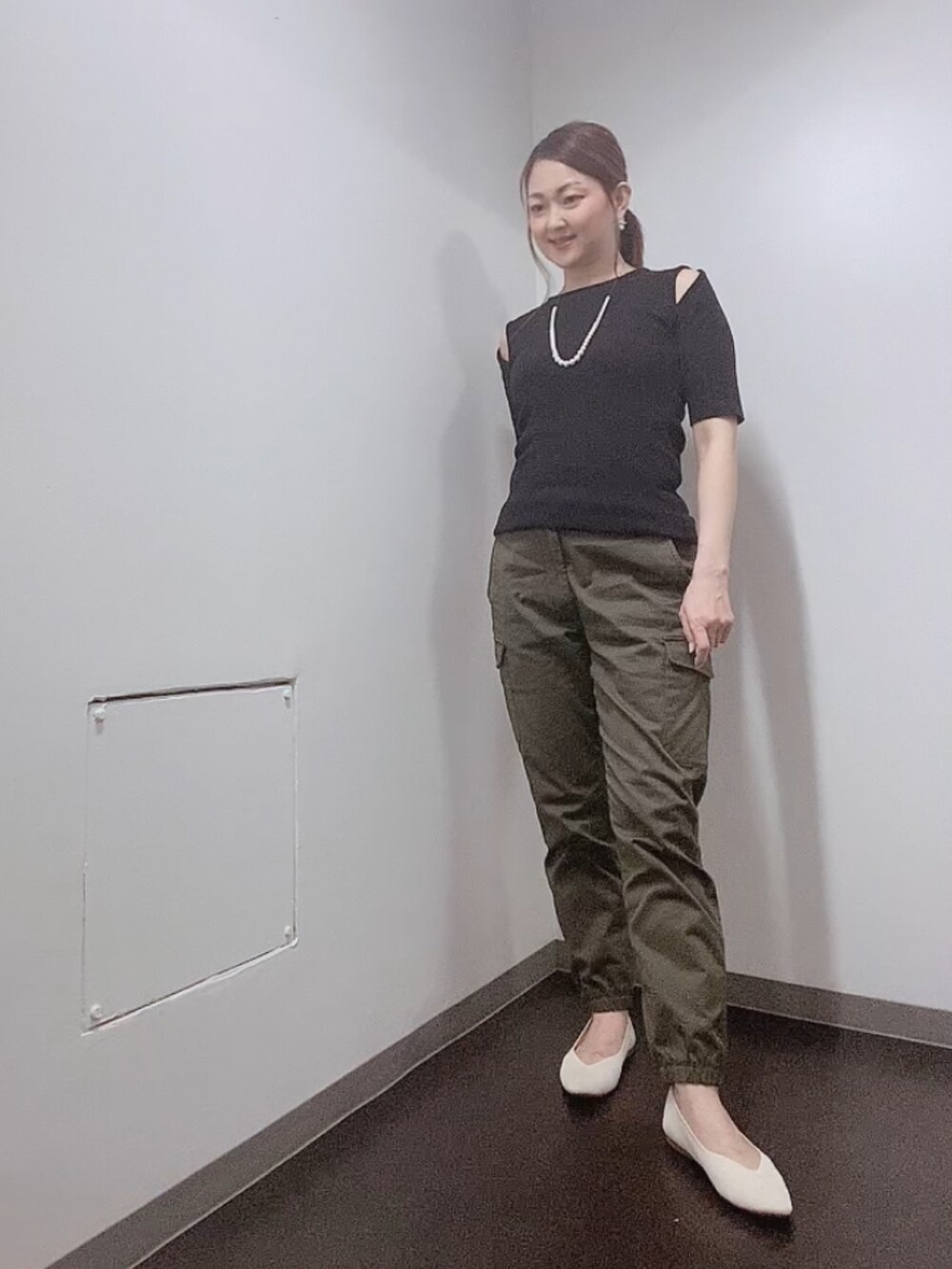 ブラック系のニット/セーター、グリーン系のカーゴパンツ、ホワイト系のバレエシューズを着用したレディースの夏コーディネートの2枚目の写真