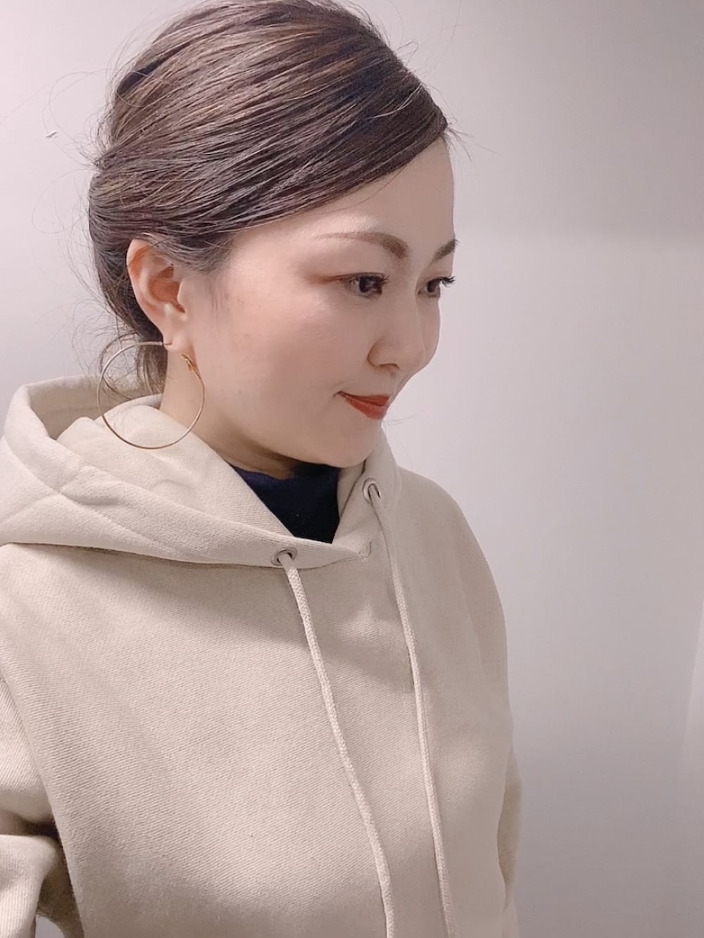 ベージュ系のパーカー、ブルー系のスカート、ブラック系のブーツを着用したレディースの冬コーディネートの5枚目の写真