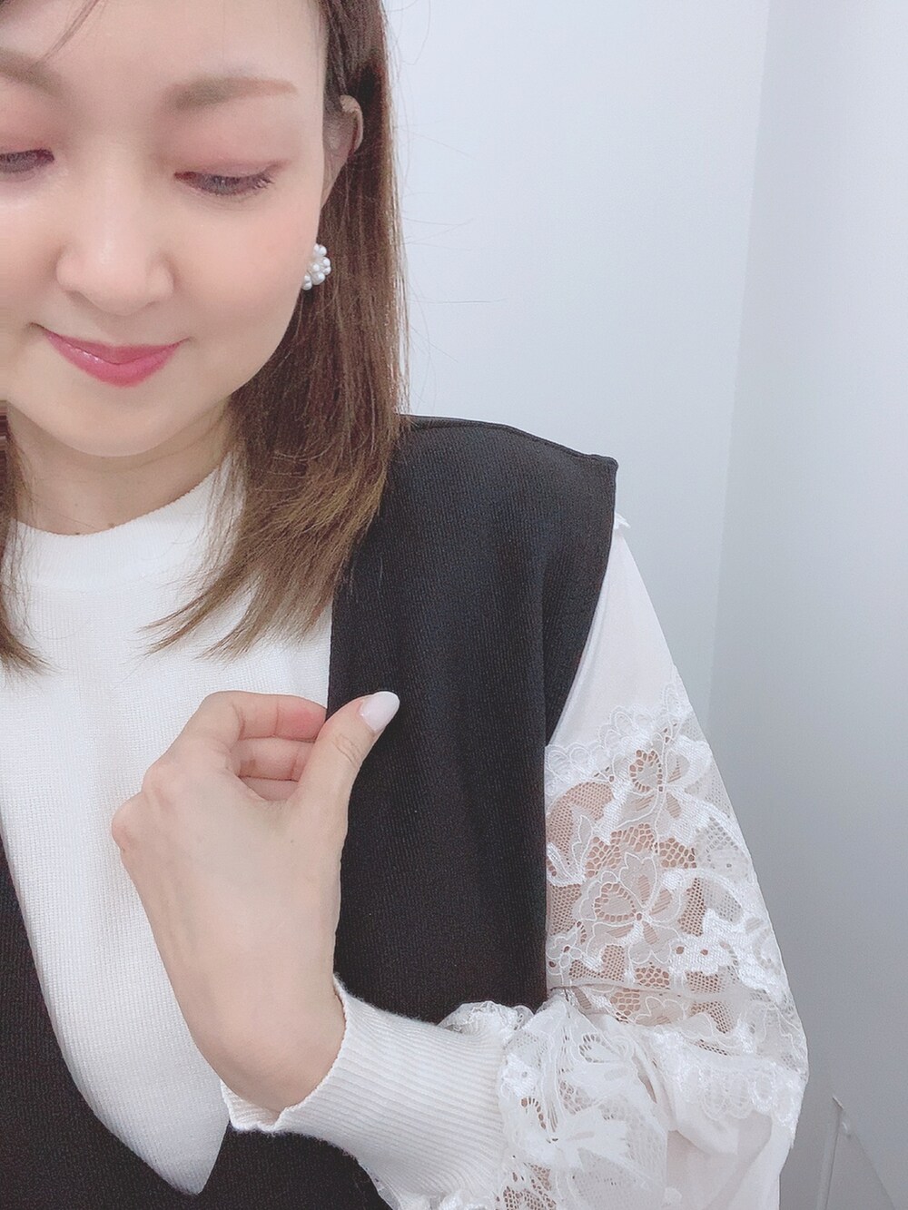 ホワイト系のニット/セーター、ブラック系のジャンパースカート、ホワイト系のレインシューズを着用したレディースの春コーディネートの5枚目の写真