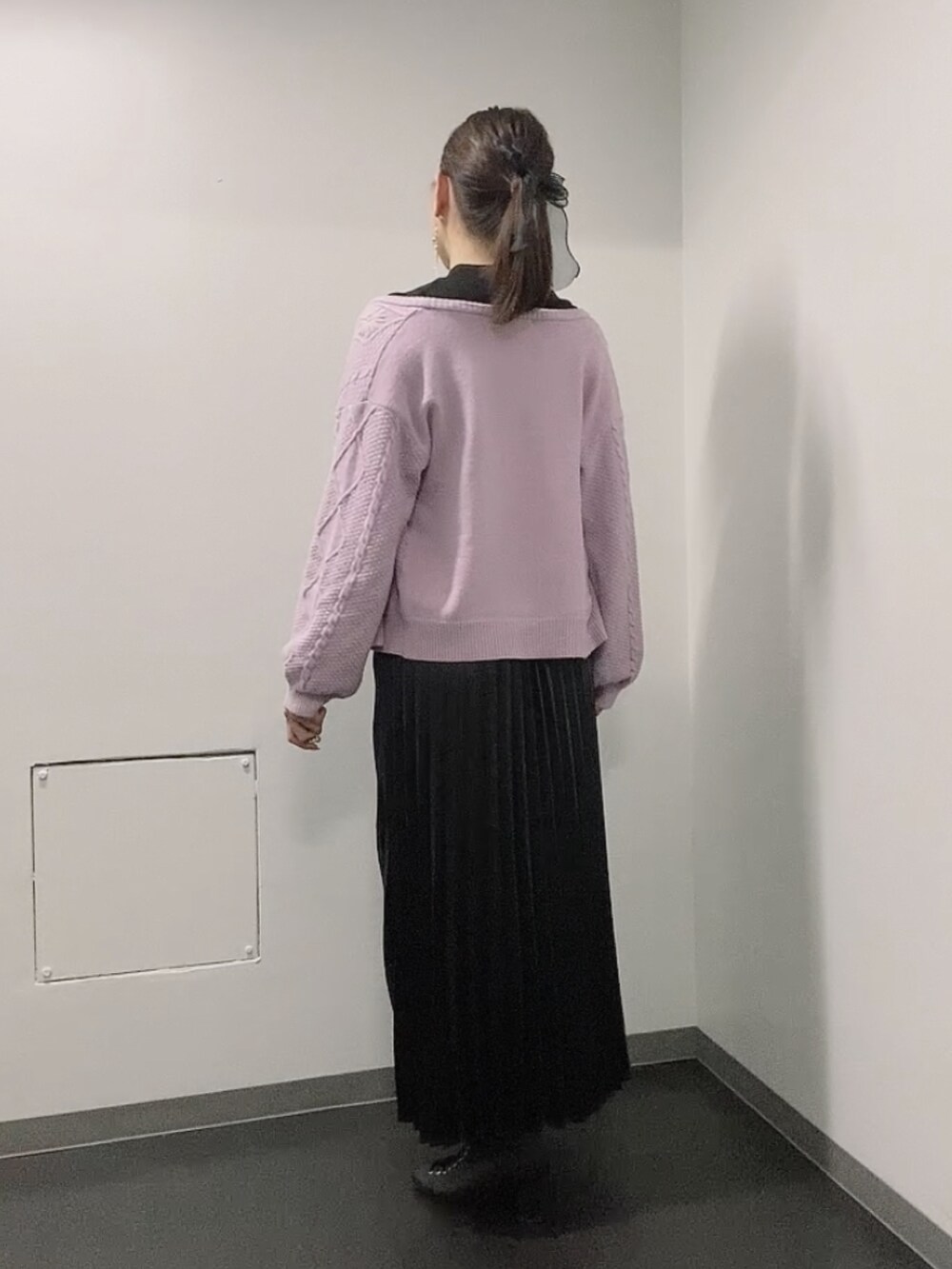 ブラック系のニット/セーター、ブラック系のスカート、ブラック系のブーツを着用したレディースの秋コーディネートの3枚目の写真