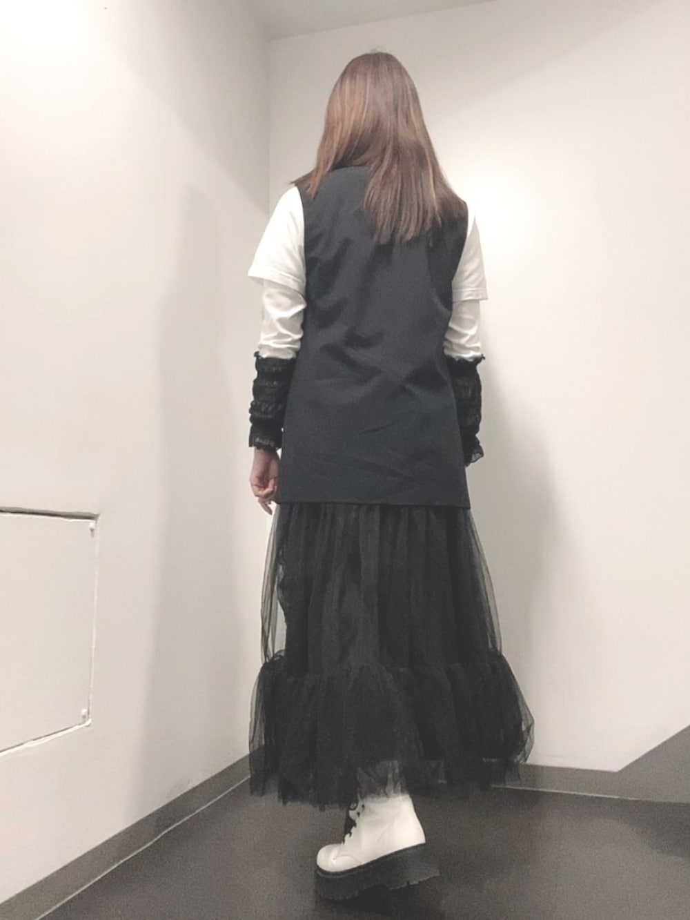 ホワイト系のTシャツ/カットソー、ブラック系のベスト、ブラック系のスカートを着用したレディースの春コーディネートの3枚目の写真