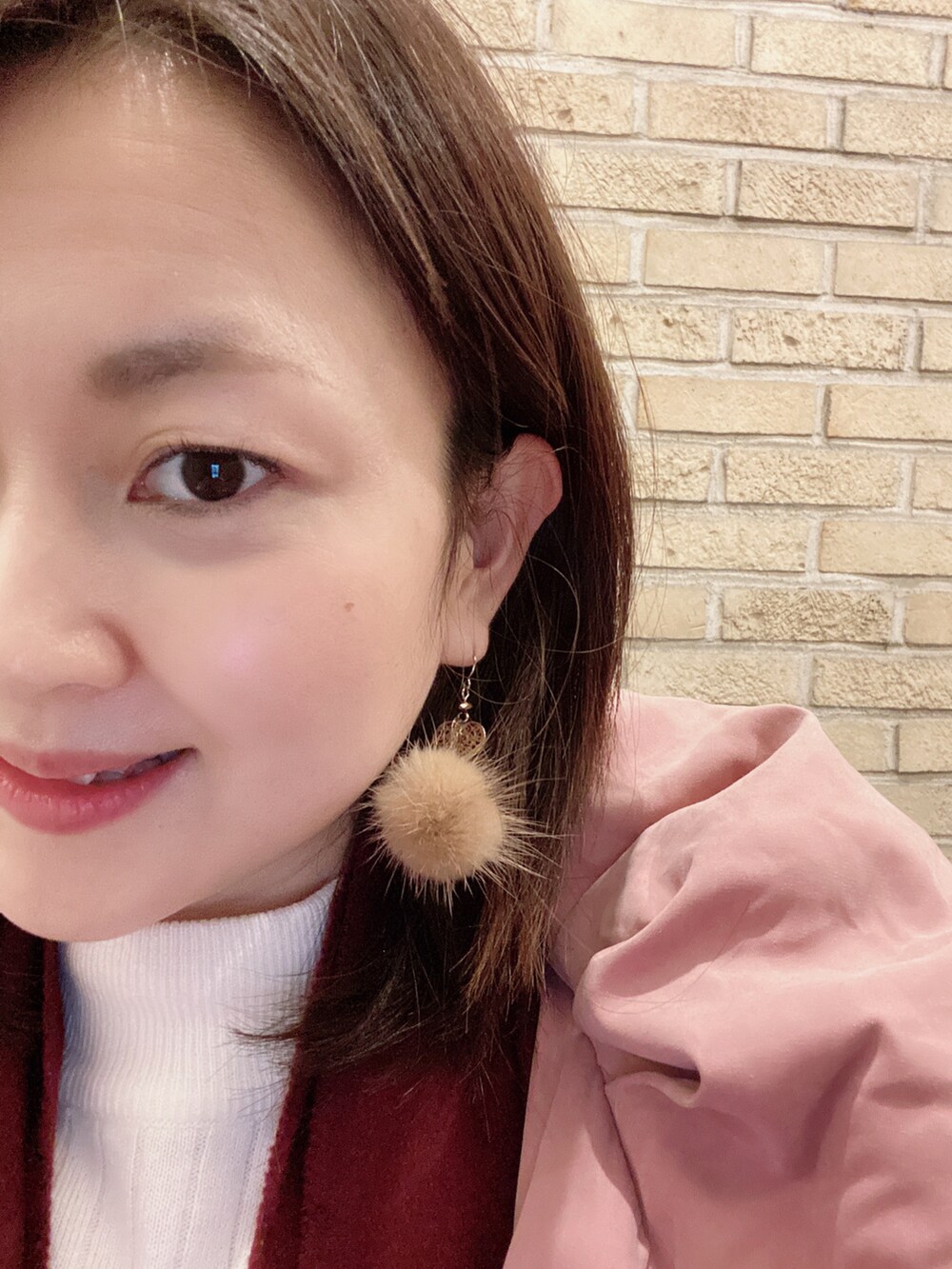 ホワイト系のニット/セーター、ベージュ系のスカート、ブラック系のブーツを着用したレディースの冬コーディネートの3枚目の写真