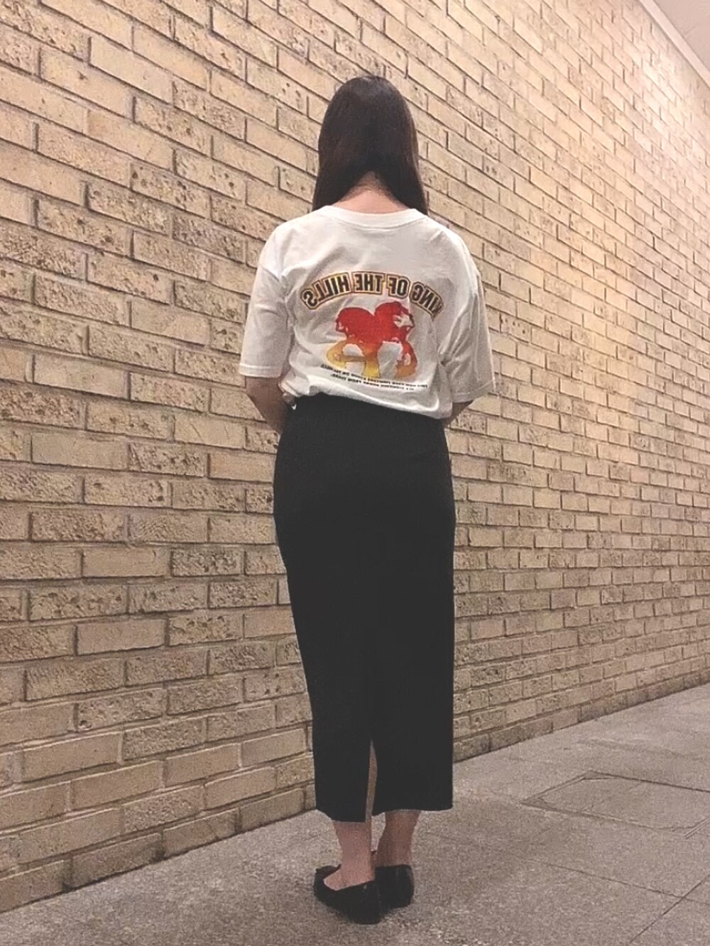 ホワイト系のTシャツ/カットソー、ブラック系のスカート、ブラック系のレインシューズを着用したレディースの夏コーディネートの3枚目の写真