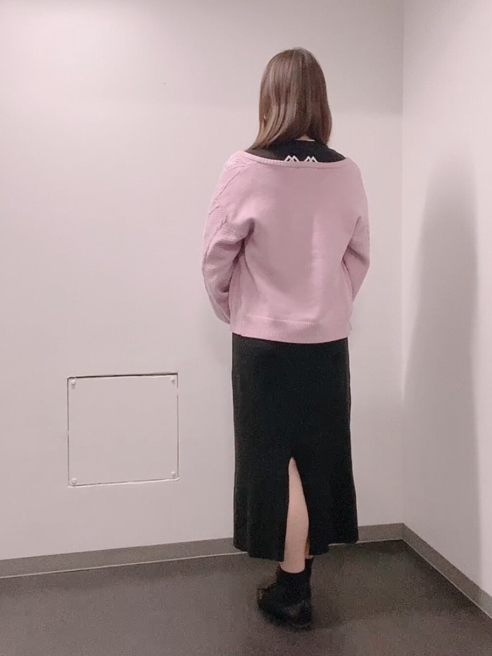 ブラック系のTシャツ/カットソー、ピンク系のカーディガン/ボレロ、ブラック系のスカートを着用したレディースの冬コーディネートの3枚目の写真