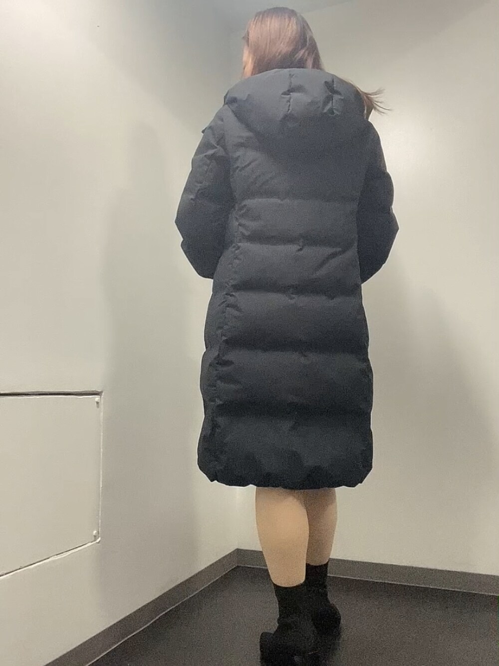 ブラック系のダウンジャケット/コート、グリーン系のニット/セーター、ベージュ系のスカートを着用したレディースの冬コーディネートの4枚目の写真