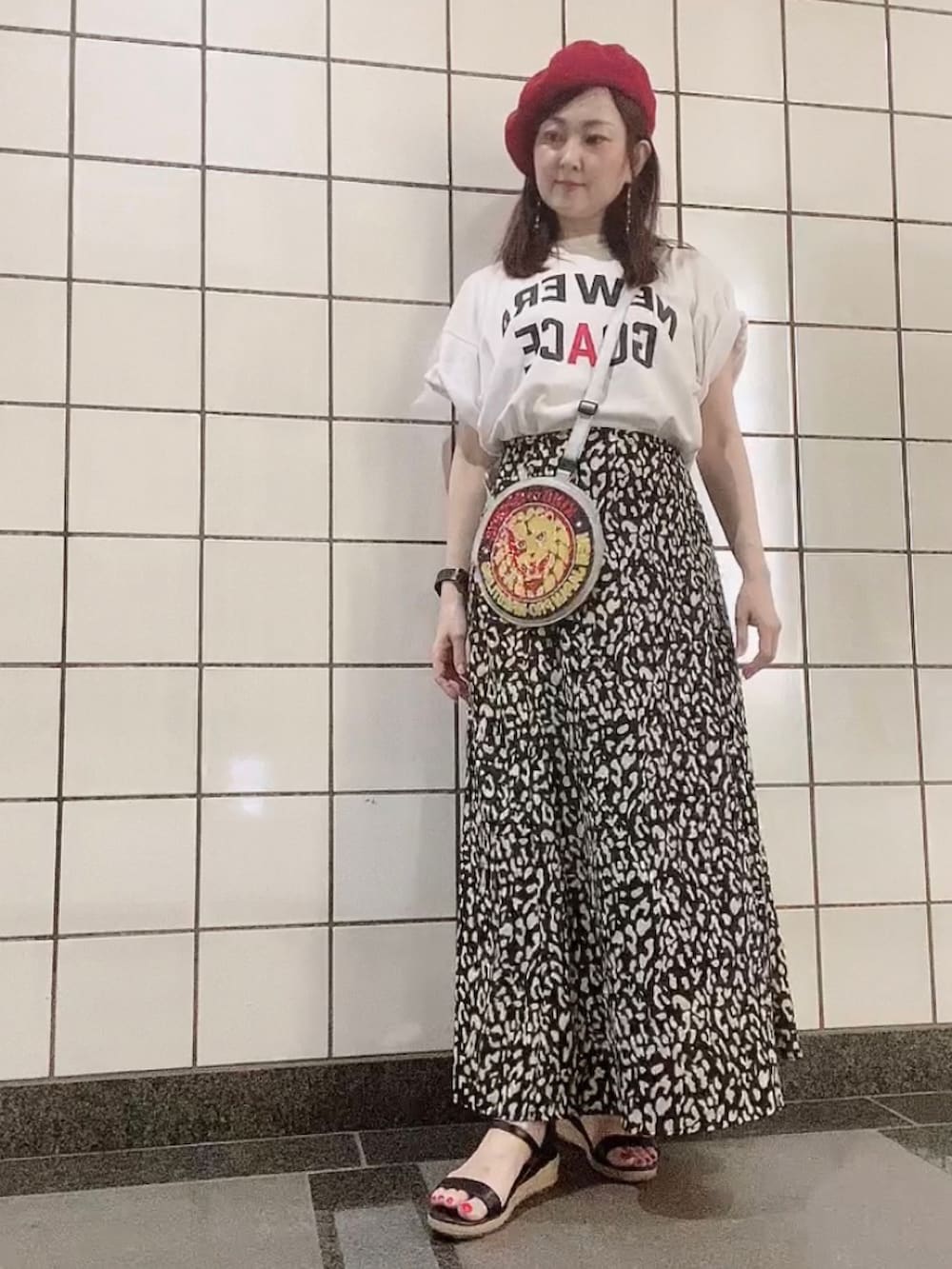 ホワイト系のTシャツ/カットソー、ブラック系のスカート、ブラック系のサンダルを着用したレディースの秋コーディネートの4枚目の写真