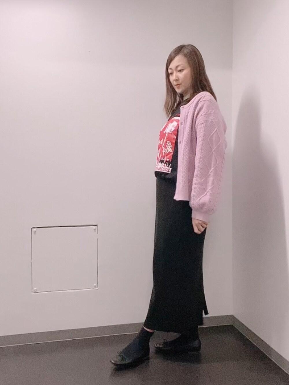 ブラック系のTシャツ/カットソー、ピンク系のカーディガン/ボレロ、ブラック系のスカートを着用したレディースの冬コーディネートの2枚目の写真