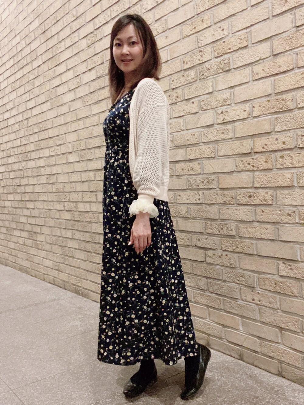 ブルー系のワンピース、ブラック系のパンプス、ホワイト系のカーディガン/ボレロを着用したレディースの夏コーディネートの2枚目の写真