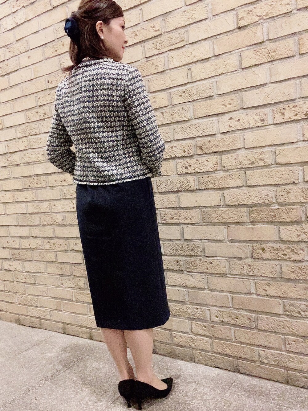 ブルー系のスーツセット、ブラック系のパンプス、ホワイト系のネックレスを着用したレディースの夏コーディネートの3枚目の写真