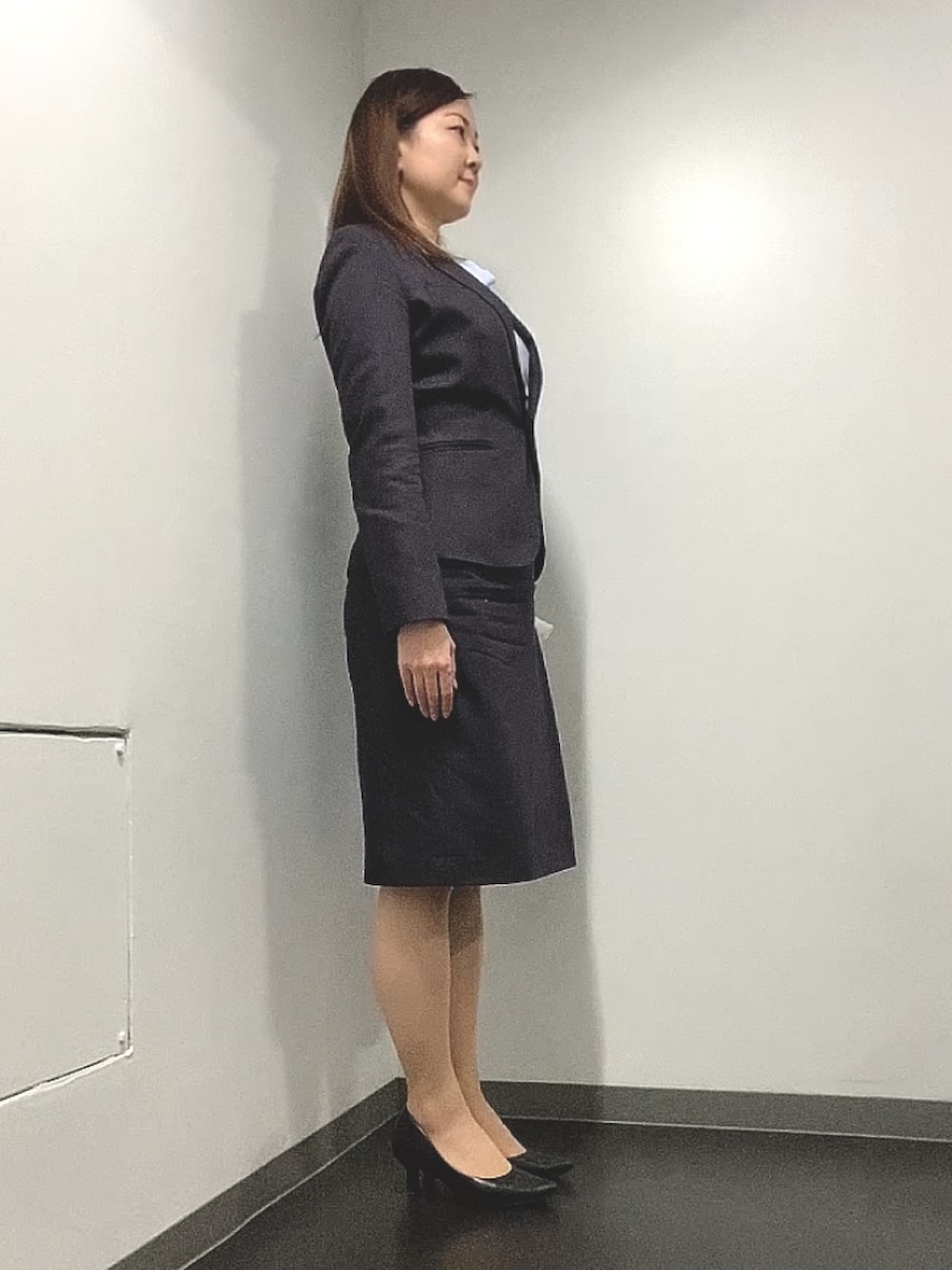 ブルー系のシャツ/ブラウス、ブラウン系のスーツセット、ブラック系のパンプスを着用したレディースの春コーディネートの2枚目の写真