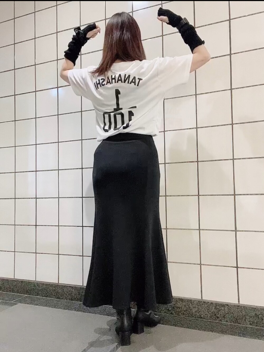 ホワイト系のTシャツ/カットソー、ブラック系のスカート、ホワイト系のショルダーバッグを着用したレディースの秋コーディネートの3枚目の写真