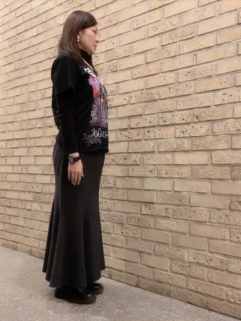 ブラック系のTシャツ/カットソー、ブラック系のスカート、ブラック系のダウンジャケット/コートを着用したレディースの冬コーディネートの2枚目の写真