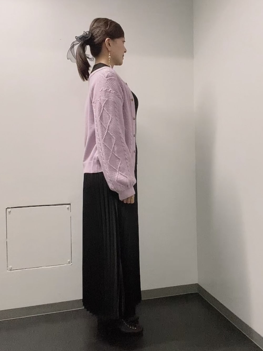 ブラック系のニット/セーター、ブラック系のスカート、ブラック系のブーツを着用したレディースの秋コーディネートの2枚目の写真