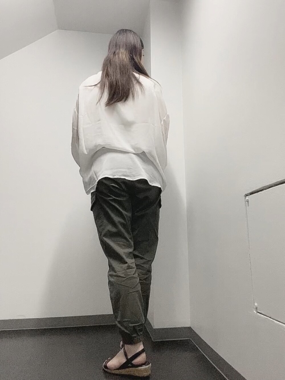 ホワイト系のTシャツ/カットソー、グリーン系のカーゴパンツ、ブラック系のサンダルを着用したレディースの夏コーディネートの3枚目の写真