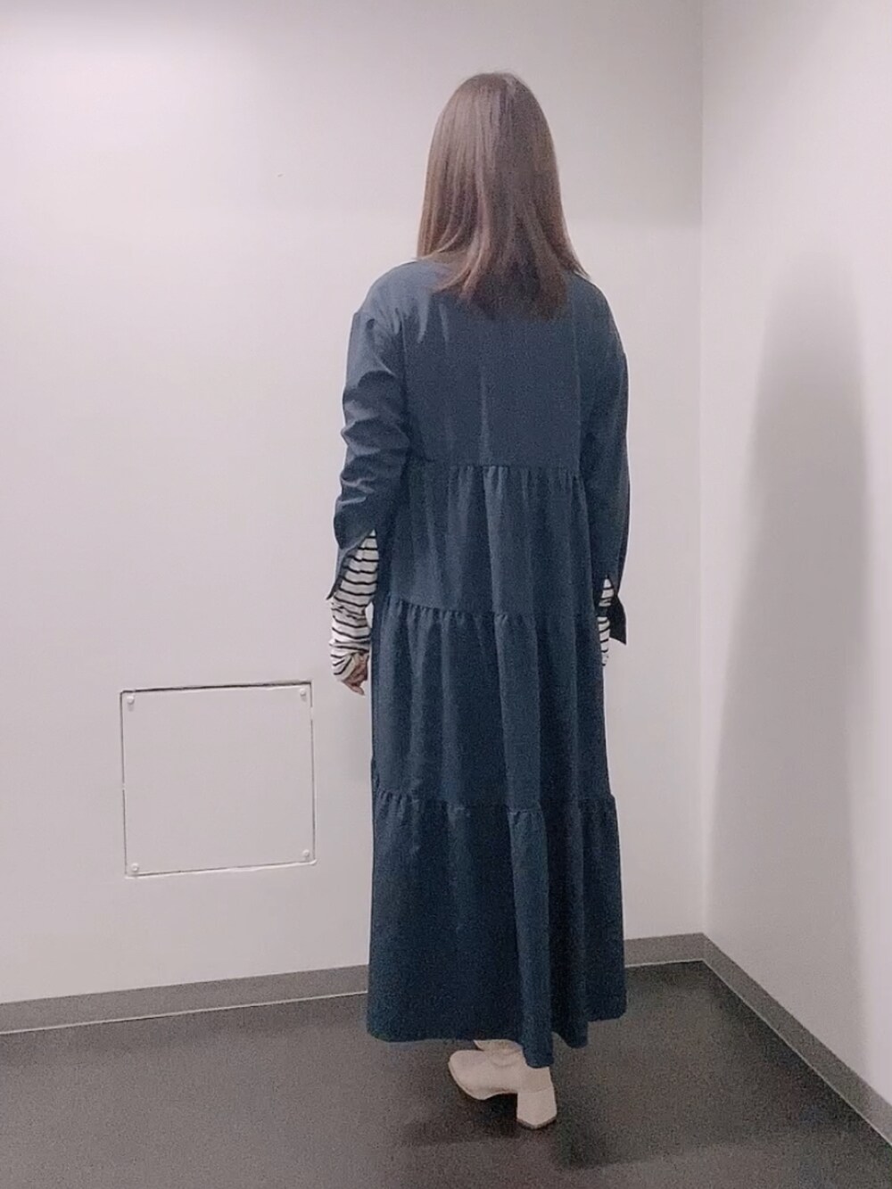 ブルー系のワンピース、ホワイト系のTシャツ/カットソー、ホワイト系のブーツを着用したレディースの冬コーディネートの3枚目の写真