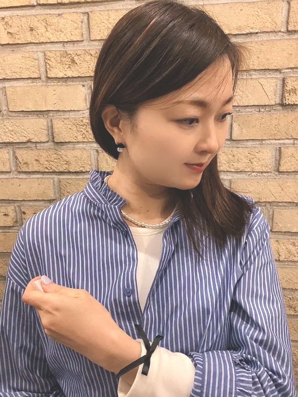 ブルー系のシャツ/ブラウス、ブラック系のカーゴパンツ、ホワイト系のレインシューズを着用したレディースの春コーディネートの5枚目の写真