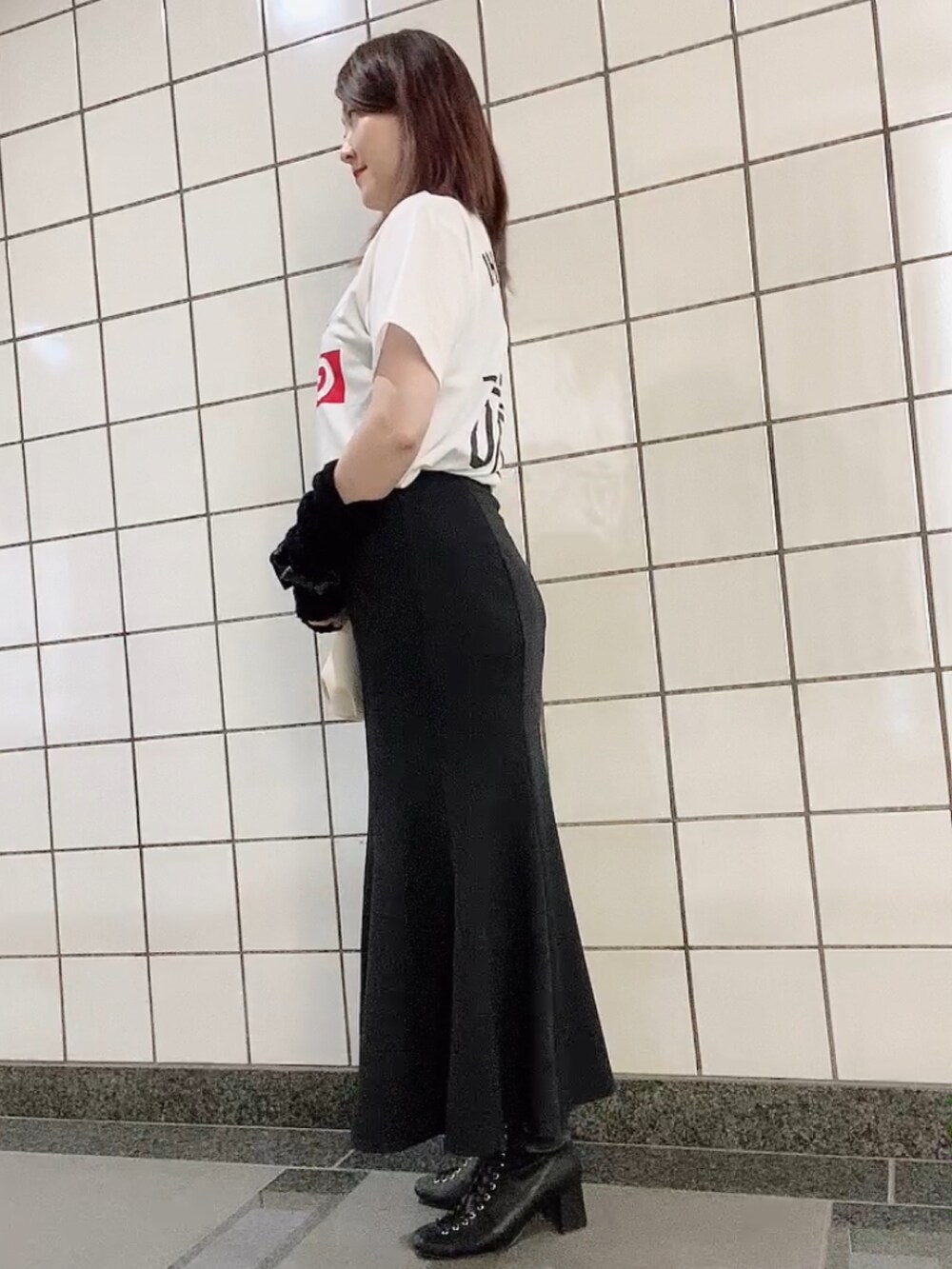 ホワイト系のTシャツ/カットソー、ブラック系のスカート、ホワイト系のショルダーバッグを着用したレディースの秋コーディネートの2枚目の写真