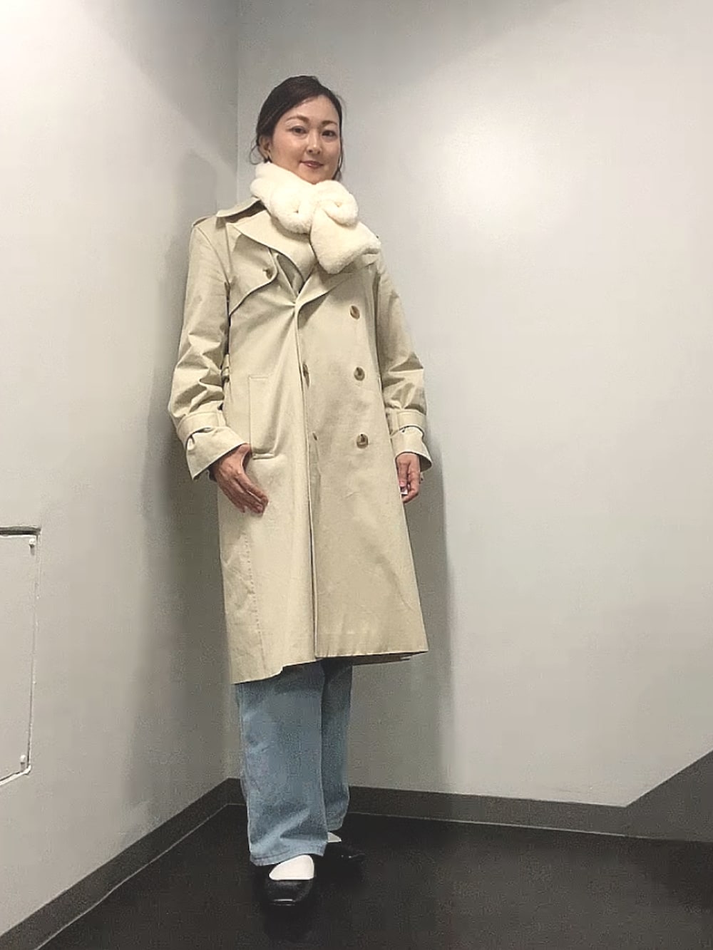 ブラック系のニット/セーター、ホワイト系のシャツ/ブラウス、ブルー系のデニムパンツを着用したレディースの春コーディネートの3枚目の写真