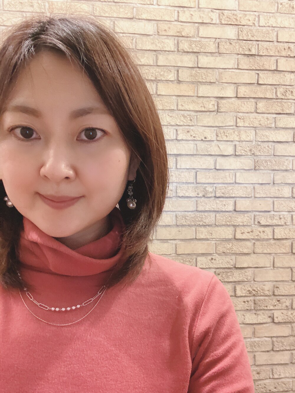 ピンク系のダウンジャケット/コート、ピンク系のTシャツ/カットソー、ブルー系のスカートを着用したレディースの冬コーディネートの3枚目の写真