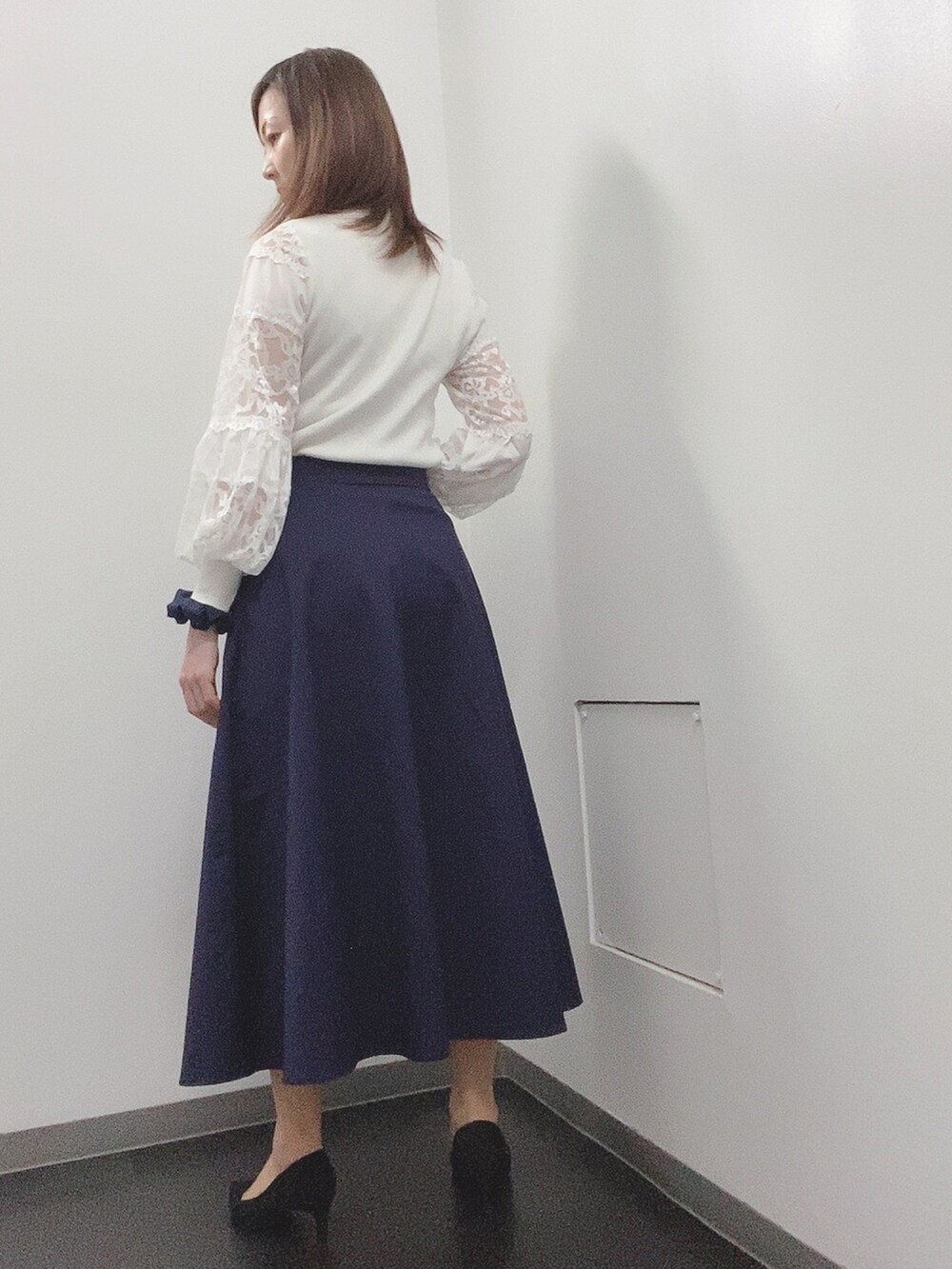 ホワイト系のニット/セーター、ブルー系のスカート、ブラック系のパンプスを着用したレディースの春コーディネートの3枚目の写真