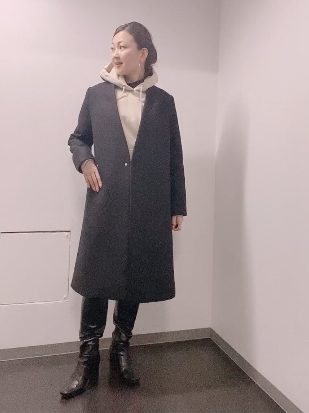 ベージュ系のパーカー、ブルー系のスカート、ブラック系のブーツを着用したレディースの冬コーディネートの4枚目の写真