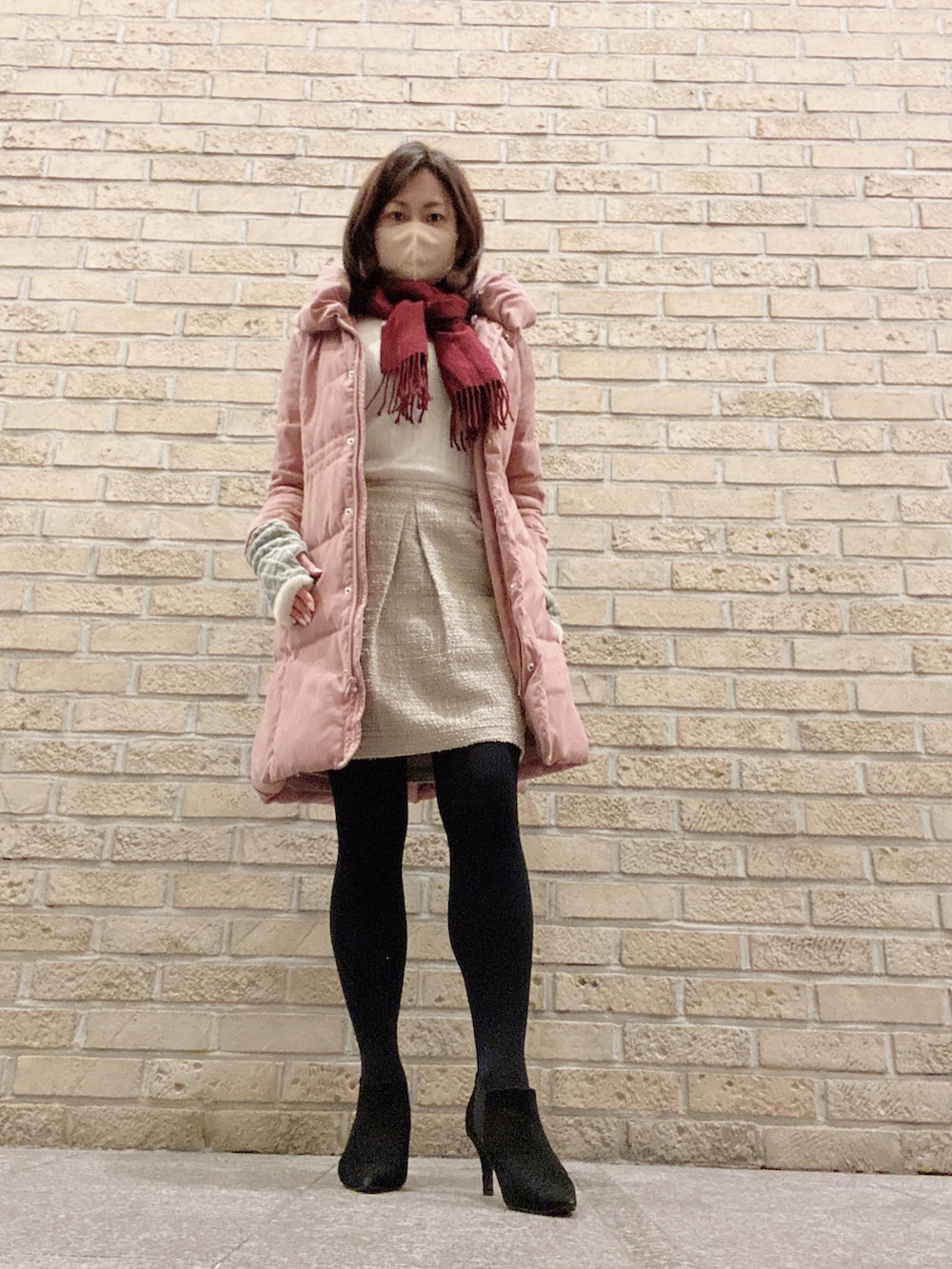 ホワイト系のニット/セーター、ベージュ系のスカート、ブラック系のブーツを着用したレディースの冬コーディネートの2枚目の写真