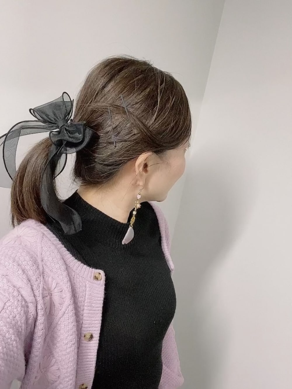 ブラック系のニット/セーター、ブラック系のスカート、ブラック系のブーツを着用したレディースの秋コーディネートの5枚目の写真