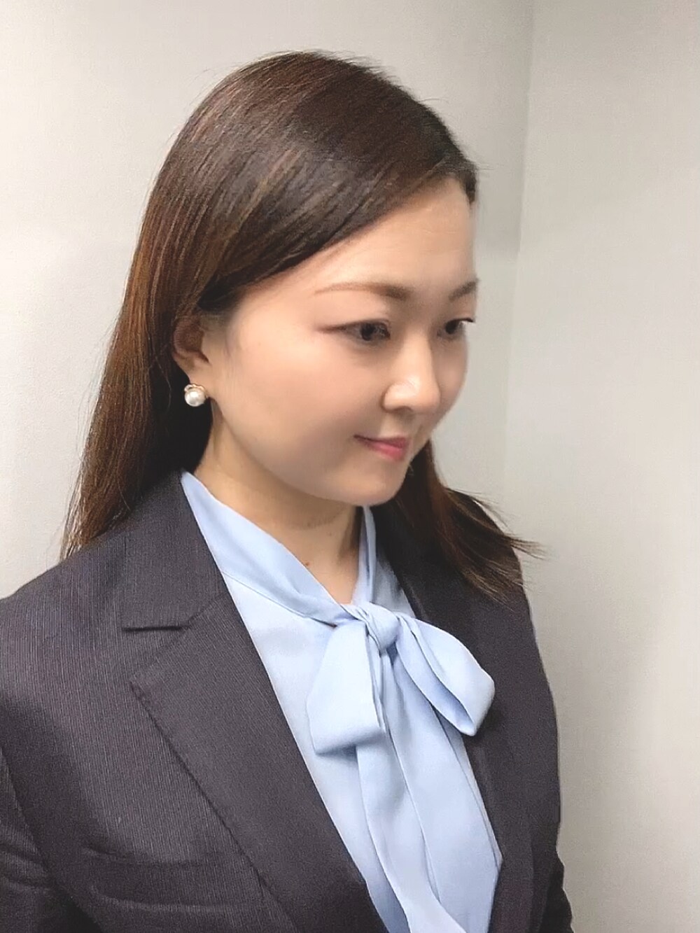 ブルー系のシャツ/ブラウス、ブラウン系のスーツセット、ブラック系のパンプスを着用したレディースの春コーディネートの5枚目の写真