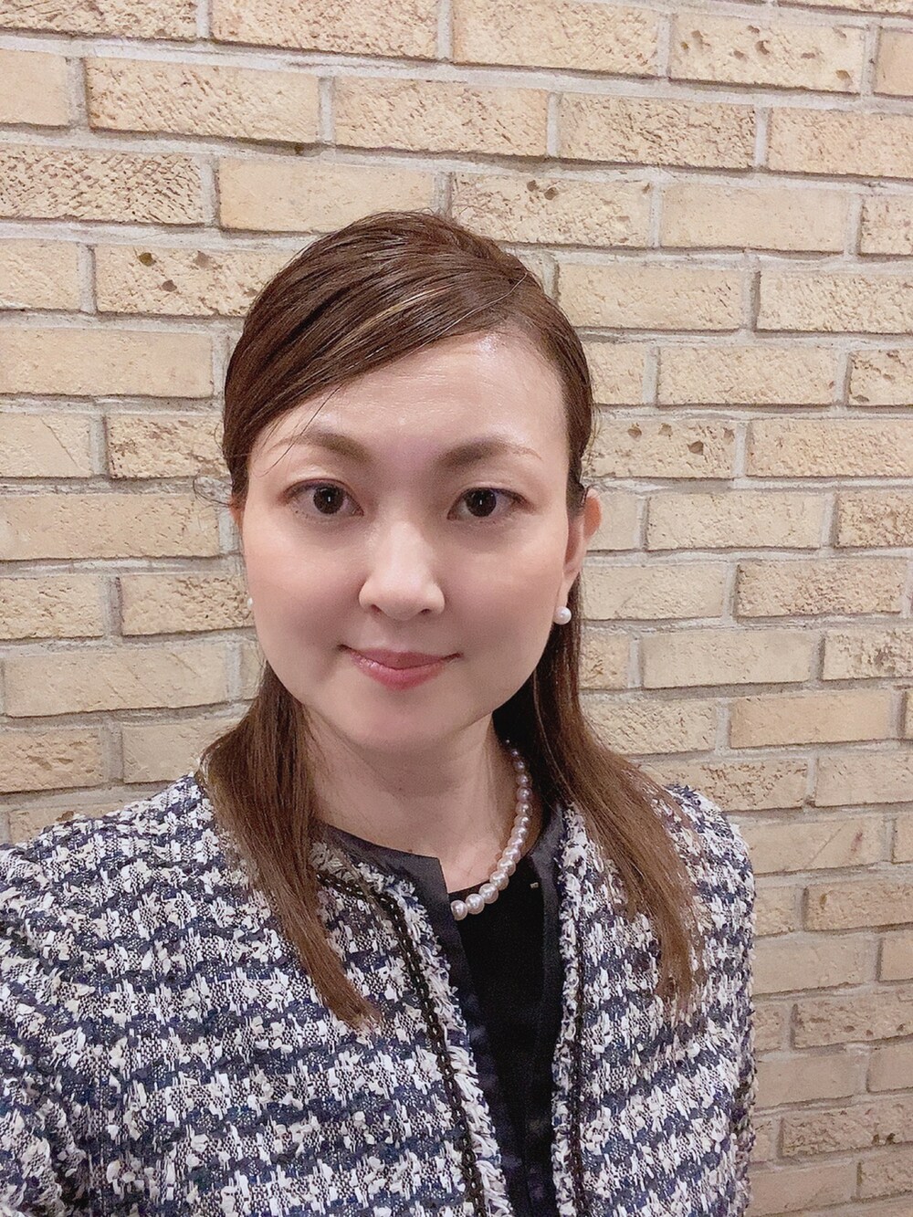 ブルー系のスーツセット、ブラック系のパンプス、ホワイト系のネックレスを着用したレディースの夏コーディネートの5枚目の写真