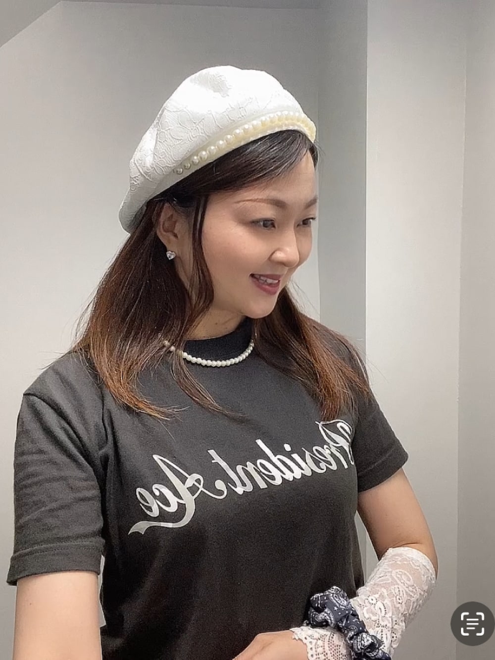 グレー系のTシャツ/カットソー、ホワイト系のスカート、ブラック系のベストを着用したレディースの夏コーディネートの5枚目の写真