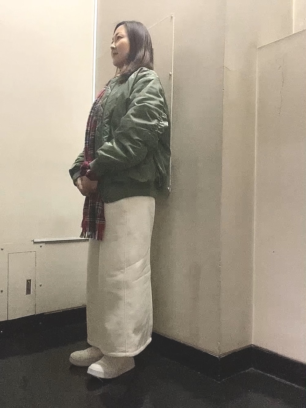 グリーン系のMA-1、ホワイト系のスカート、ホワイト系のスニーカーを着用したレディースの春コーディネートの4枚目の写真