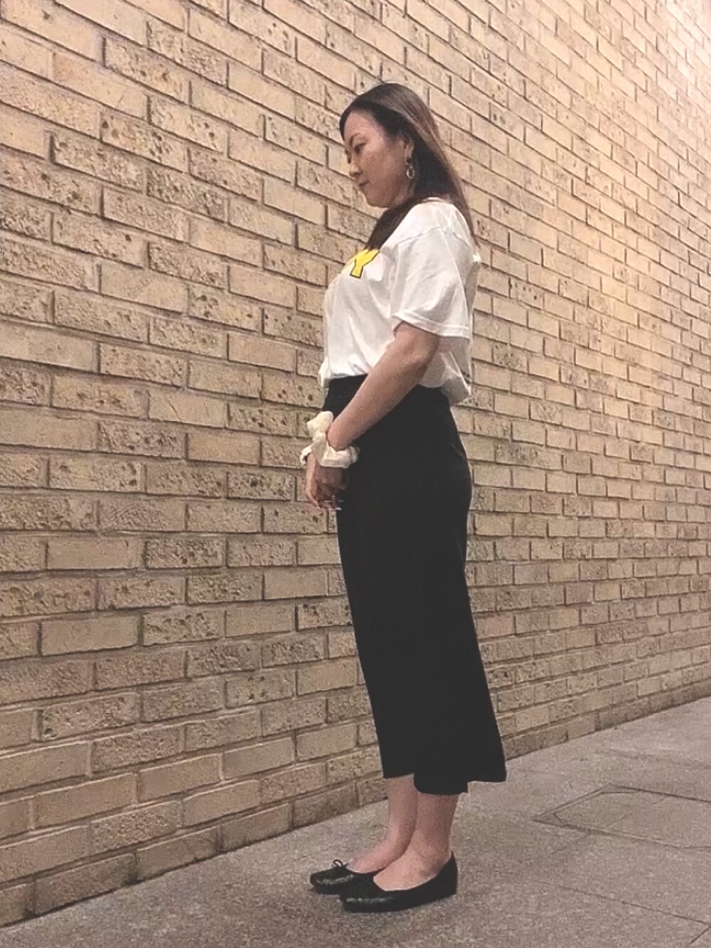 ホワイト系のTシャツ/カットソー、ブラック系のスカート、ブラック系のレインシューズを着用したレディースの夏コーディネートの4枚目の写真