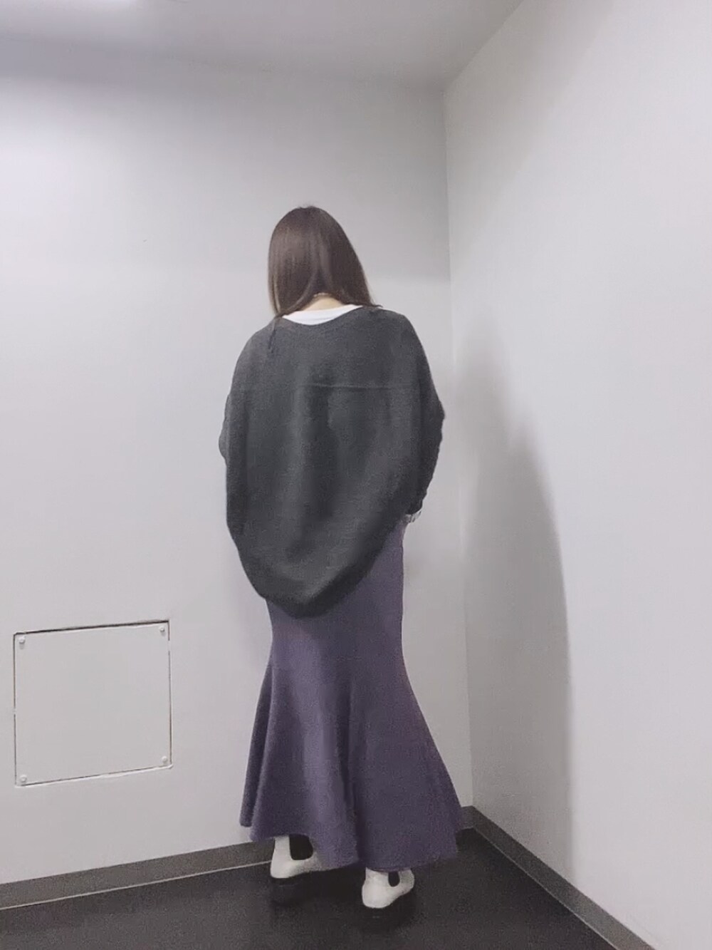ホワイト系のTシャツ/カットソー、グレー系のカーディガン/ボレロ、パープル系のスカートを着用したレディースの秋コーディネートの3枚目の写真