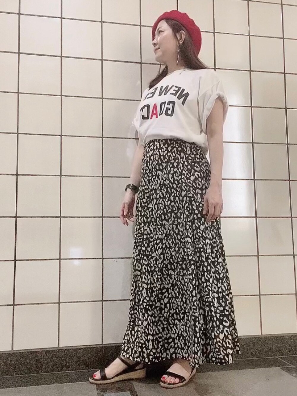 ホワイト系のTシャツ/カットソー、ブラック系のスカート、ブラック系のサンダルを着用したレディースの秋コーディネートの3枚目の写真