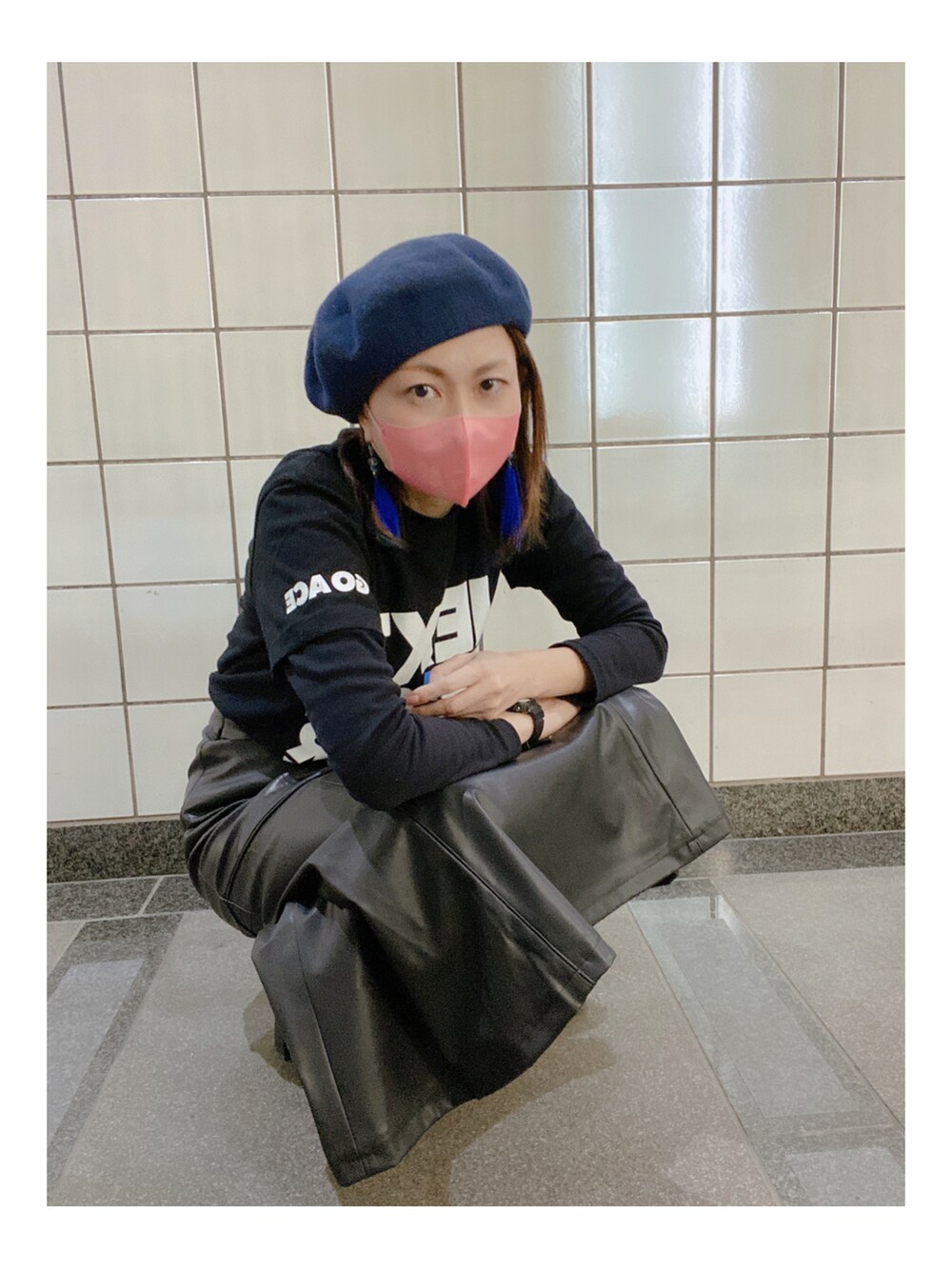 ブラック系のTシャツ/カットソー、ブラック系のスカート、ブラック系のブーツを着用したレディースの秋コーディネートの4枚目の写真