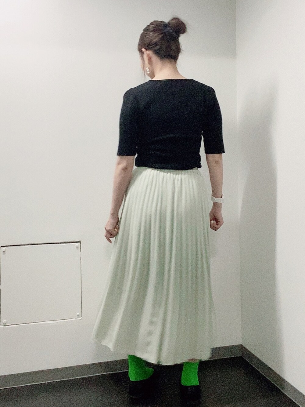 ブラック系のニット/セーター、グリーン系のスカート、ブラック系のレインシューズを着用したレディースの夏コーディネートの3枚目の写真