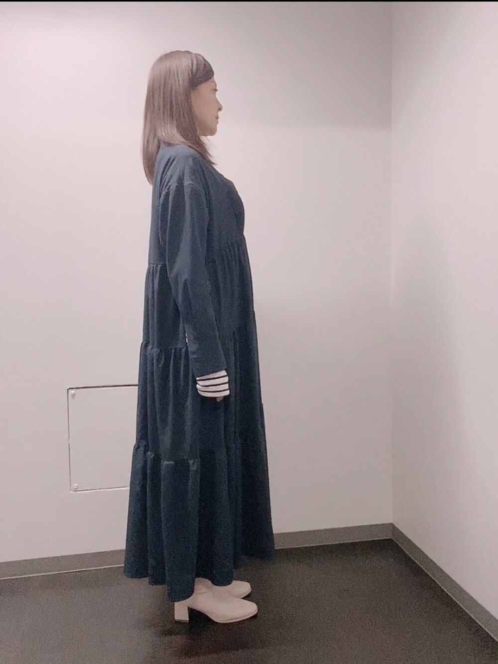 ブルー系のワンピース、ホワイト系のTシャツ/カットソー、ホワイト系のブーツを着用したレディースの冬コーディネートの2枚目の写真