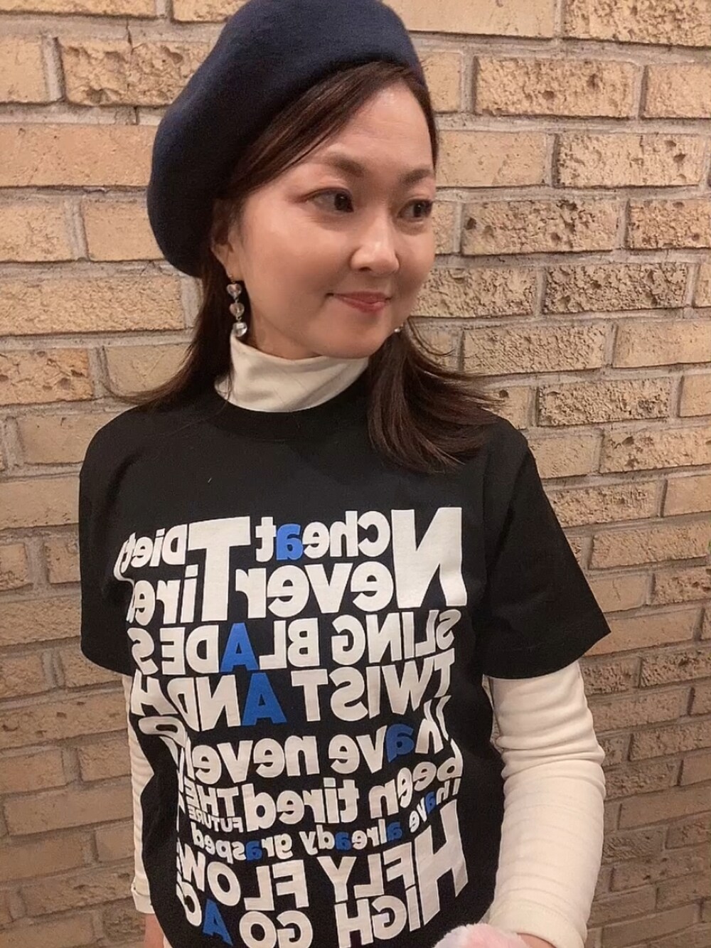 ブラック系のTシャツ/カットソー、ホワイト系のスカート、ホワイト系のTシャツ/カットソーを着用したレディースの冬コーディネートの5枚目の写真