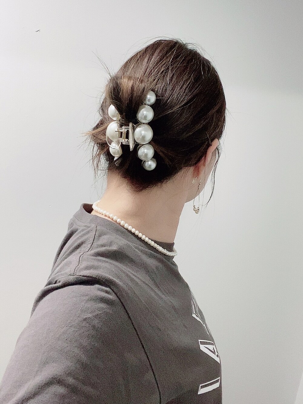 イエロー系のスラックス、ホワイト系のサンダル、グレー系のTシャツ/カットソーを着用したレディースの夏コーディネートの5枚目の写真