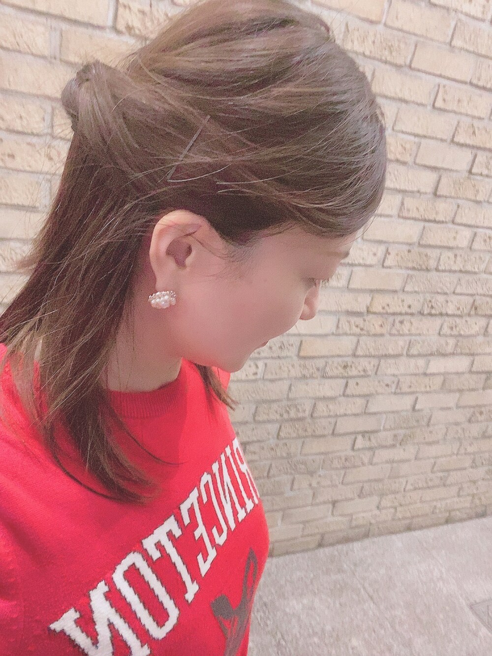 レッド系のニット/セーター、ブラック系のスカート、ホワイト系のレインシューズを着用したレディースの春コーディネートの3枚目の写真