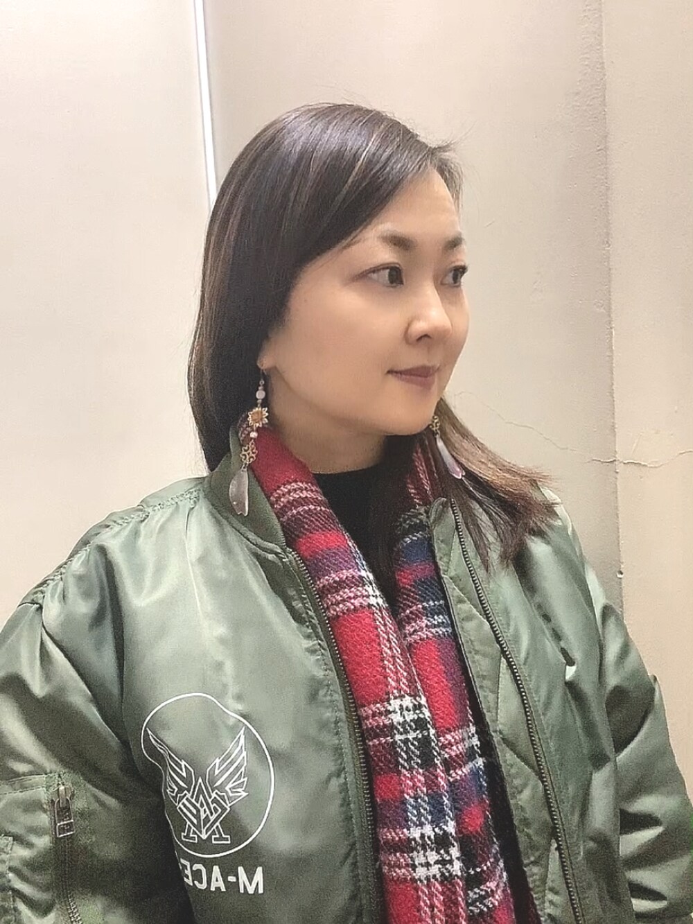 グリーン系のMA-1、ホワイト系のスカート、ホワイト系のスニーカーを着用したレディースの春コーディネートの5枚目の写真