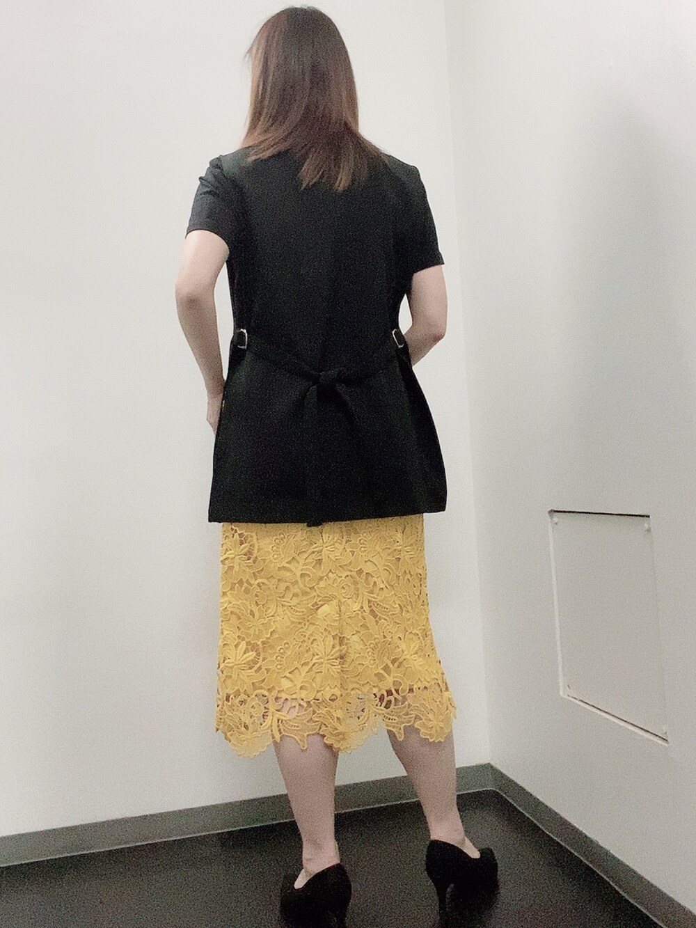 ブラック系のTシャツ/カットソー、イエロー系のスカート、ブラック系のパンプスを着用したレディースの夏コーディネートの3枚目の写真