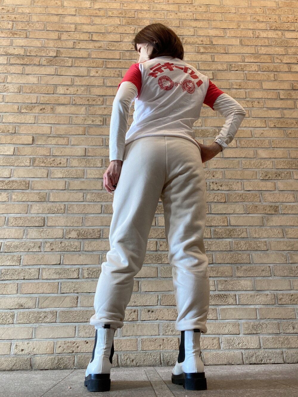 レッド系のTシャツ/カットソー、ホワイト系のスウェットパンツ、ホワイト系のレインシューズを着用したレディースの冬コーディネートの2枚目の写真