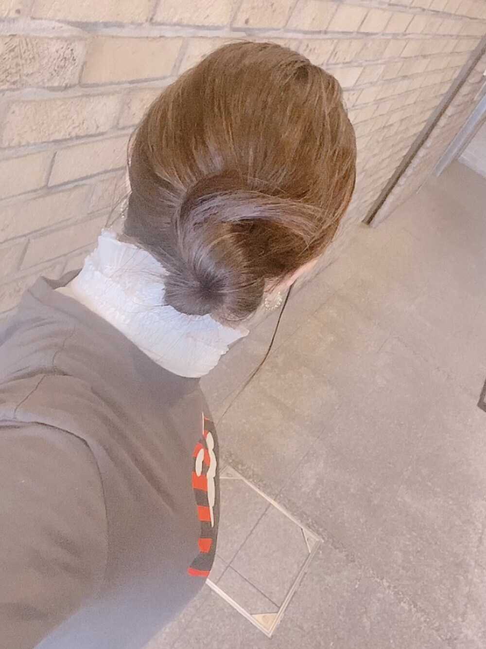 グレー系のTシャツ/カットソー、ブラック系のスカート、ホワイト系のレインシューズを着用したレディースの冬コーディネートの5枚目の写真